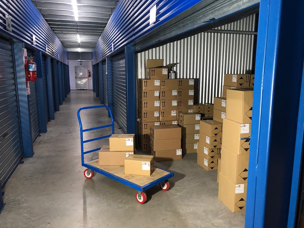 Pasillo de bauleras con cajas y un carro de carga